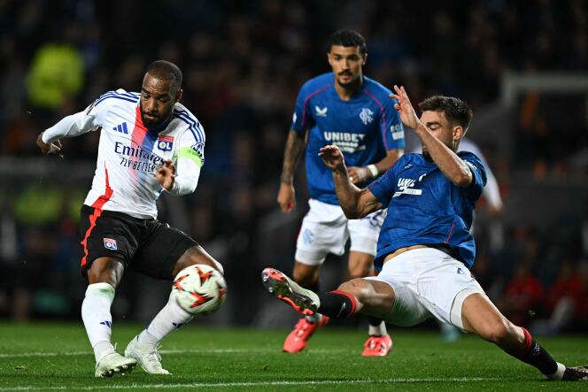 Le défenseur des Rangers Robin Pröpper (maillot bleu) tente de contrer l’attaquant lyonnais Alexandre Lacazette, le 3 octobre 2024, à l’Ibrox Stadium de Glasgow.